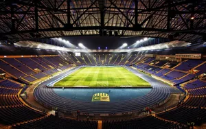 A Soccer Field With Blue Seats Wallpaper
