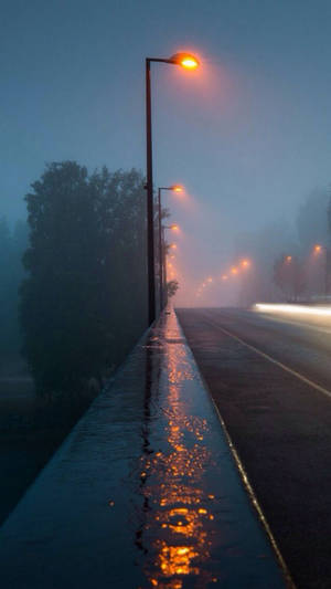 A Spectacular Sight Of Rainfall On A Misty Highway Wallpaper