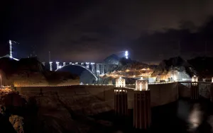 A Spellbinding View Of The Hoover Dam Illuminated At Night. Wallpaper
