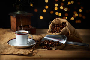 A Steamy Mug Of Fresh Hot Coffee Surrounded By Aromatic Coffee Beans. Wallpaper