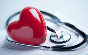 A Stethoscope And Plastic Heart Representing Mbbs Studies Wallpaper