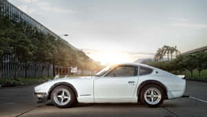 A Stunning Blue Datsun In A Radiant Outdoor Setting Wallpaper
