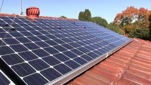 A Sustainable House With Solar Panels On The Brown Roof Wallpaper