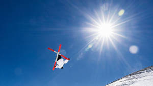 A Thrilling Mid-air Ski Jumping Moment Wallpaper