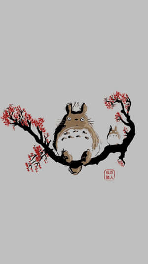 A Totoro Sitting On A Branch With Red Flowers Wallpaper