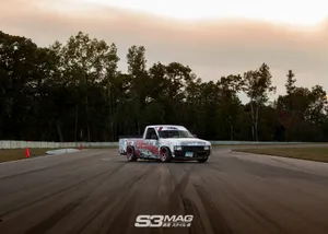 A Truck Driving Down A Track In The Evening Wallpaper