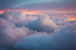 A Vast Sea Of Clouds Cascading Across A Serene Blue Sky. Wallpaper