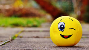 A Vibrant Yellow Smiling Ball Symbolizing Happiness And Positivity Wallpaper