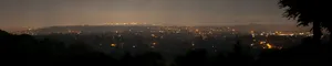 A View Of A City At Night With Lights Wallpaper