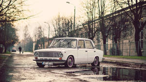 A Vintage Car In The Street Of Riga Wallpaper