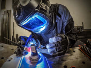 A Welder Working On A Metal Piece Wallpaper