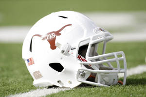 A White Football Helmet Sits On The Field Wallpaper