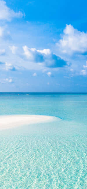 A White Sandy Beach With Clear Water Wallpaper