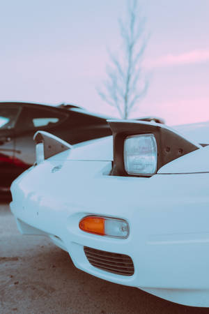 A White Sports Car Parked Next To A Black Car Wallpaper