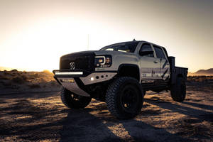 A White Truck Is Parked In The Desert Wallpaper