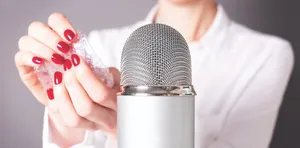 A Woman Holding A Microphone With Her Nails On It Wallpaper
