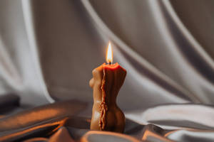 A Woman In Tranquil Meditation With A Holistic Lit Candle. Wallpaper