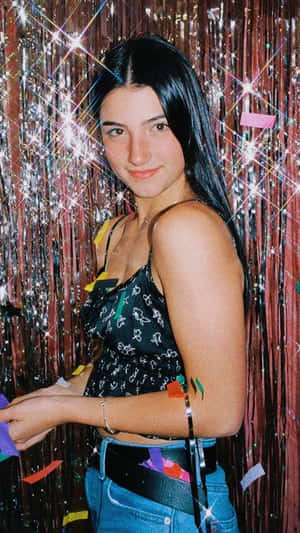 A Woman Is Standing In Front Of A Confetti Wall Wallpaper