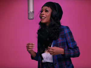 A Woman Singing Into A Microphone Wallpaper