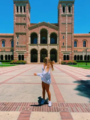 A Woman Standing In Front Of A Large Building Wallpaper