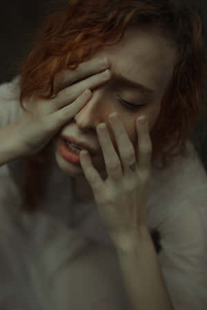 A Woman With Red Hair Covering Her Eyes Wallpaper
