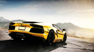 A Yellow Sports Car Driving Down A Road Wallpaper