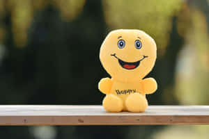A Yellow Stuffed Animal With The Word Happy On It Wallpaper