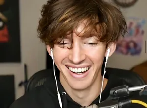 A Young Man Is Smiling While Wearing Headphones Wallpaper