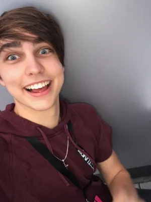 A Young Man Smiling While Sitting On A Toilet Wallpaper