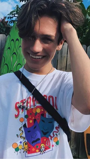 A Young Man Wearing A T - Shirt With A Cartoon Character On It Wallpaper