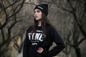 A Young Woman Wearing A Black Sweatshirt And Beanie Wallpaper