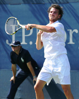 Adrian Mannarino Executing A Powerful Backhand Shot In A Tennis Match Wallpaper