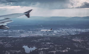Aerial_ View_of_ Airplane_ Wing_and_ Second_ Aircraft_ Mid_ Flight Wallpaper