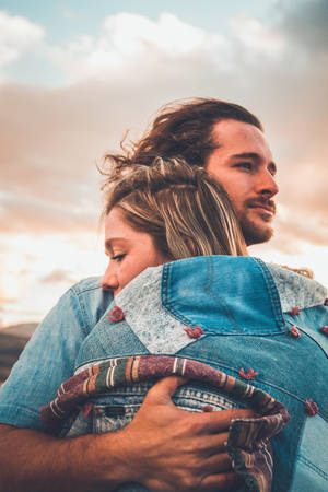 Aesthetic Couple Hugging On A Windy Day Wallpaper