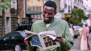 African Man Reading Happily Wallpaper