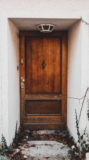 Aged Elegance: The Old Wooden Door Of An Abandoned House Wallpaper