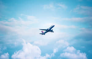 Airplane Ascending Against Blue Sky Wallpaper