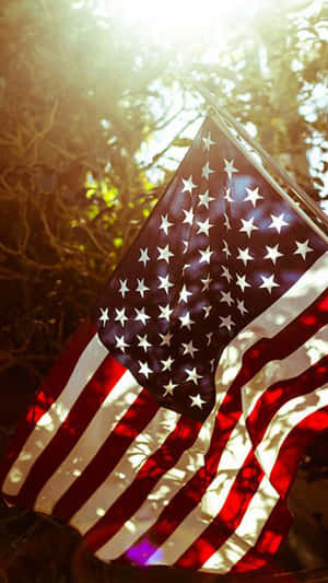 An American Flag Is Flying In The Sun Wallpaper