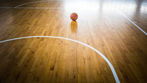 An Awe-inspiring View Of The Game – A Close-up Shot Of A Basketball On A Concrete Court Wallpaper