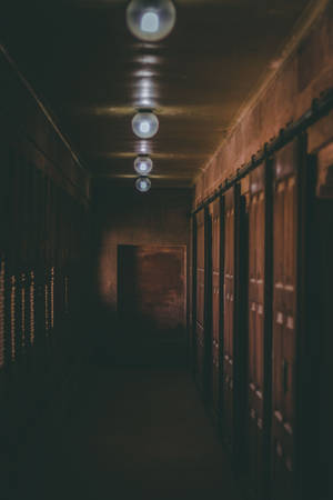 An Eerily Empty Hallway Illuminated With Dim Light Wallpaper