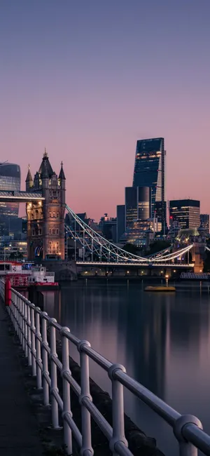 An Iphone Towers Over London’s Iconic Skyline. Wallpaper