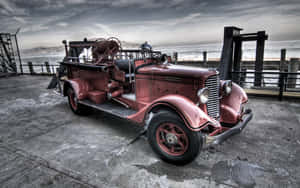 An Old Fire Truck Parked On A Dock Wallpaper