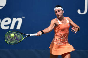 Anastasija Sevastova Dominating The Court In Peach Tennis Dress Wallpaper