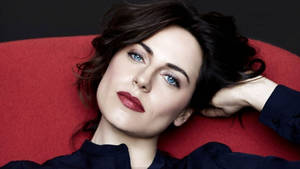 Antje Traue In A Red Chair Wallpaper