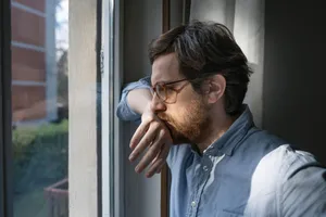 Anxious Man Looking Out The Window Wallpaper