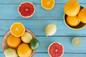 Assorted Citrus Fruitson Blue Wooden Background Wallpaper