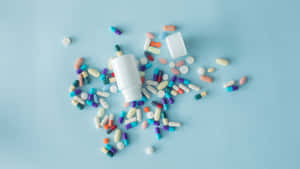 Assorted Medicationsand Pill Bottleon Blue Background Wallpaper