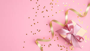Baby Pink Gift Box With A Golden Ribbon Wallpaper