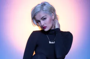 Bebe Rexha Striking A Pose On Stage Wallpaper