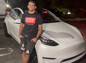 Beneil Dariush Leaning Against A Car Wallpaper